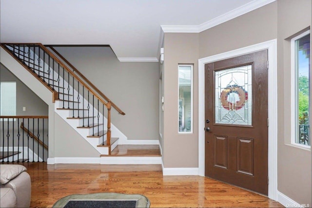 entrance foyer featuring ornamental molding and light hardwood / wood-style flooring