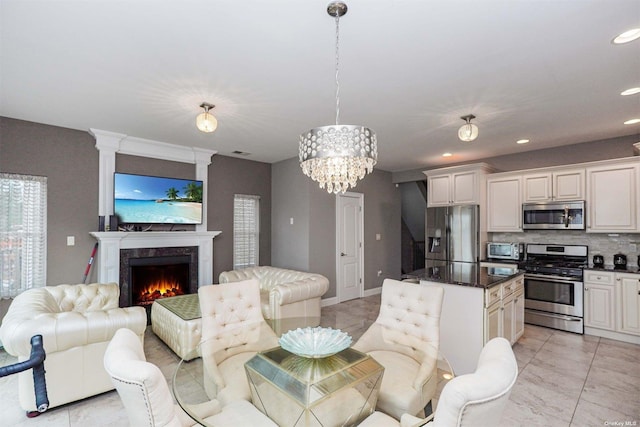 kitchen featuring stainless steel appliances, a center island, a high end fireplace, decorative backsplash, and decorative light fixtures