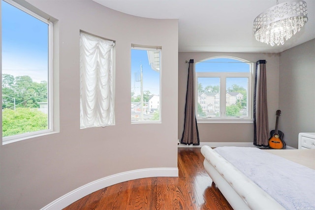 bedroom with an inviting chandelier and dark wood-type flooring