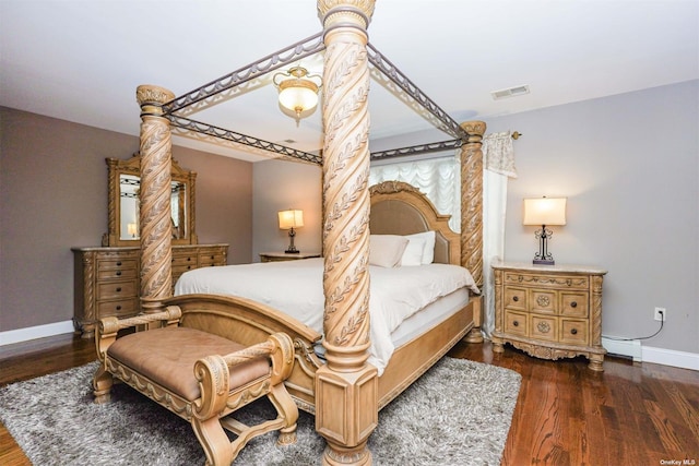 bedroom featuring dark wood-type flooring and a baseboard heating unit