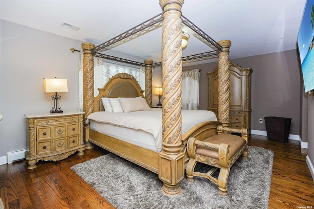 bedroom with a baseboard radiator and dark hardwood / wood-style floors