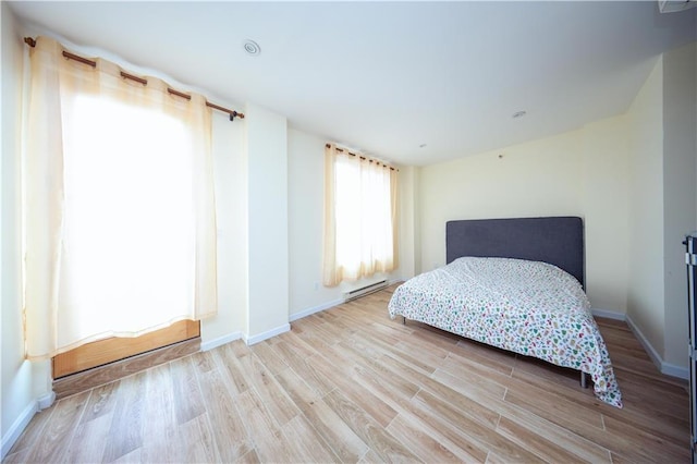 bedroom featuring a baseboard radiator and light wood-type flooring