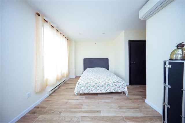 bedroom featuring an AC wall unit and a baseboard heating unit