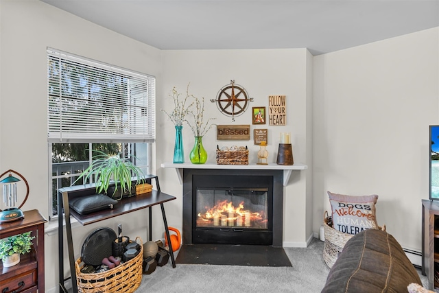 interior space with a fireplace with flush hearth, a baseboard heating unit, and carpet floors