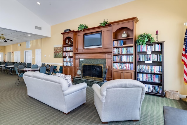 living area featuring visible vents, vaulted ceiling, a fireplace, dark carpet, and recessed lighting