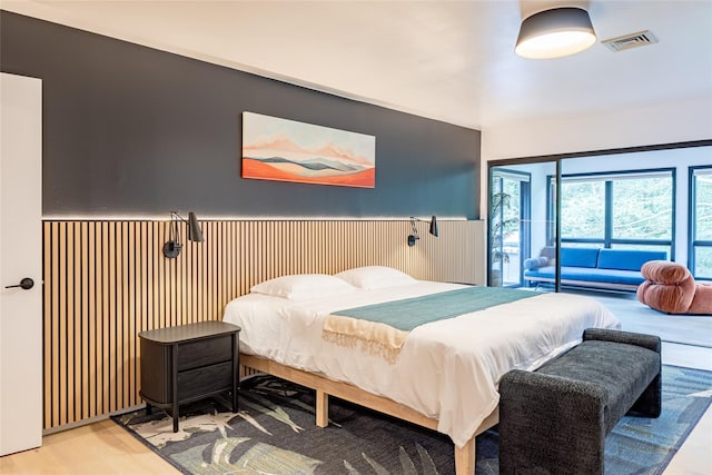 bedroom featuring access to exterior and light hardwood / wood-style flooring