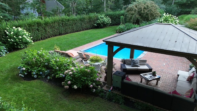 view of pool featuring a yard, an outdoor living space, and a patio