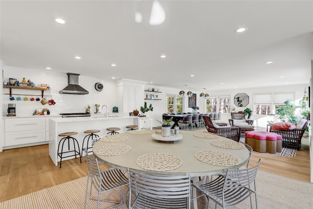 dining space with light hardwood / wood-style flooring and sink