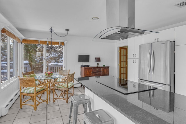 kitchen with stainless steel refrigerator, baseboard heating, hanging light fixtures, white cabinets, and island exhaust hood