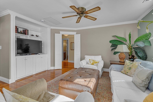 living room with wood-type flooring, ceiling fan, built in features, and crown molding