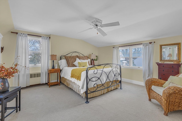 bedroom featuring multiple windows, radiator heating unit, vaulted ceiling, and light carpet