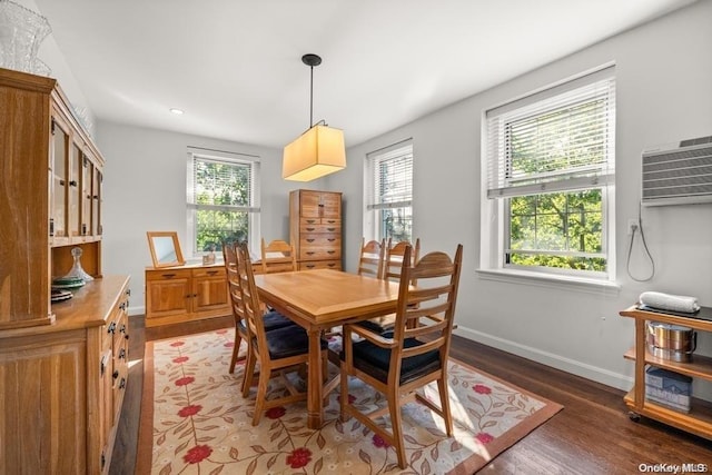 dining room featuring dark wood-type flooring and a wall mounted AC