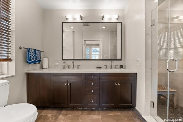 bathroom featuring vanity, walk in shower, and toilet