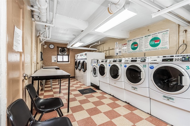 clothes washing area featuring washer and dryer and wood walls