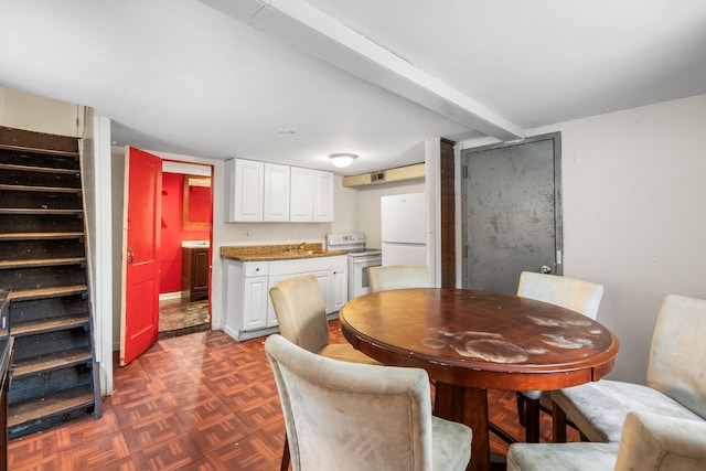 dining area featuring dark parquet flooring, washer / dryer, and sink