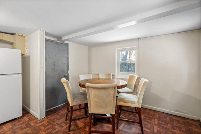 dining area featuring beamed ceiling and dark parquet floors