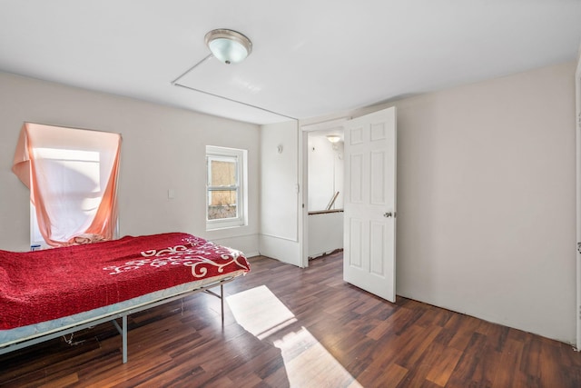 bedroom with dark hardwood / wood-style flooring