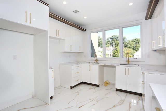 kitchen featuring white cabinetry and sink