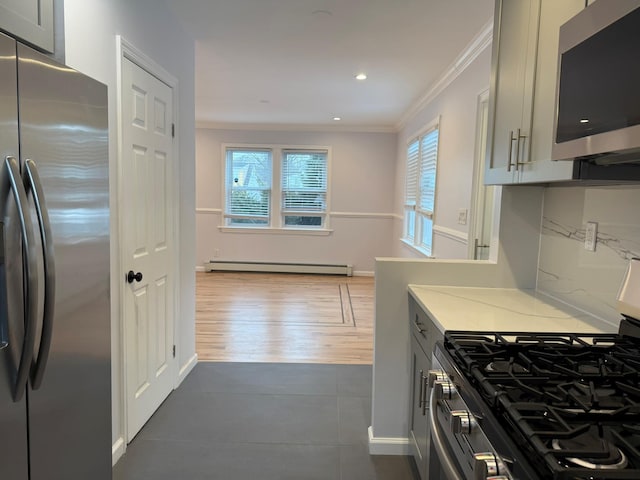 kitchen featuring tasteful backsplash, ornamental molding, appliances with stainless steel finishes, gray cabinets, and a baseboard heating unit