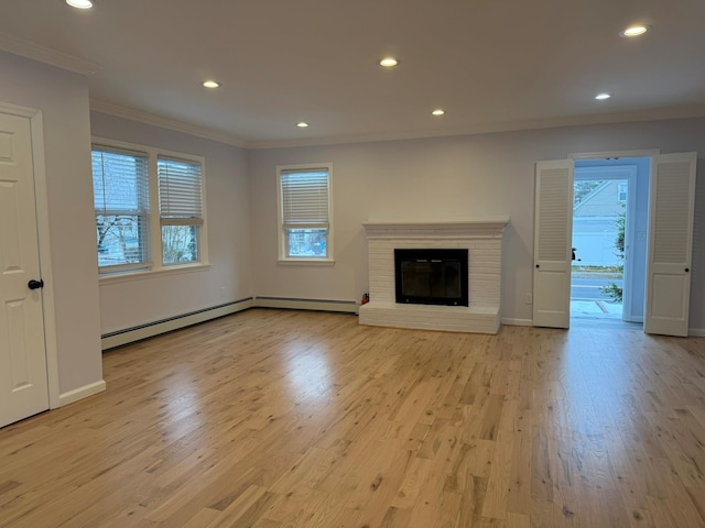 unfurnished living room with ornamental molding, a brick fireplace, light wood-type flooring, and a baseboard radiator