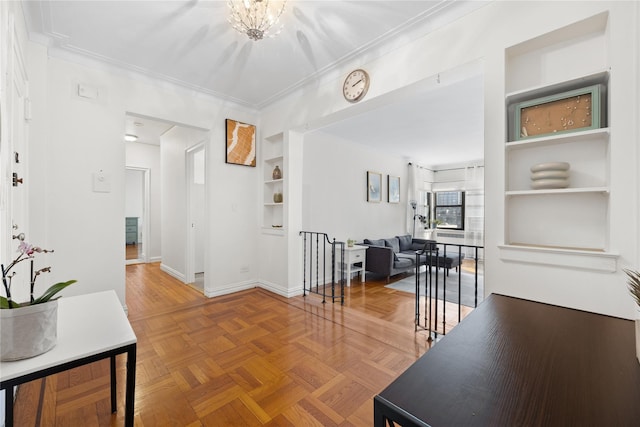 hall featuring built in shelves, crown molding, an upstairs landing, a chandelier, and baseboards