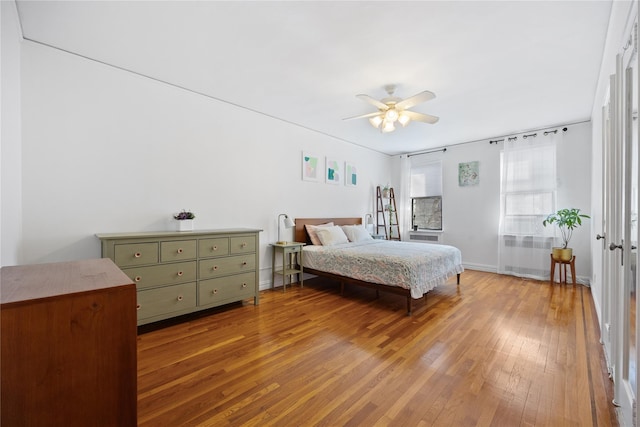 bedroom featuring wood-type flooring, ceiling fan, and baseboards