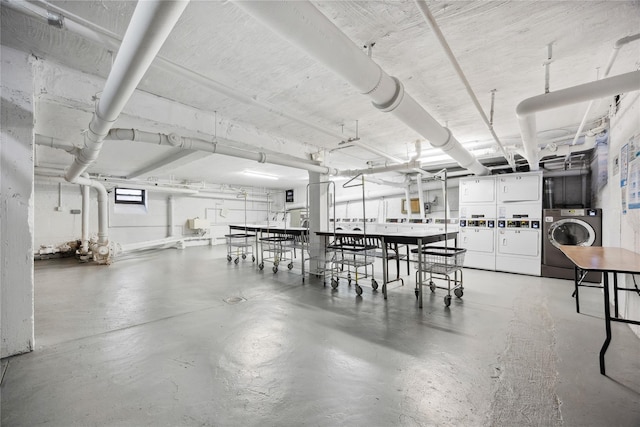 dining space with washer and dryer, concrete flooring, and stacked washer / drying machine