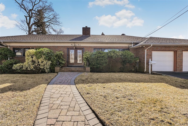 single story home with a garage and a front yard