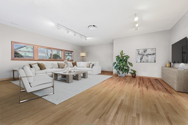 living room featuring light hardwood / wood-style flooring and rail lighting