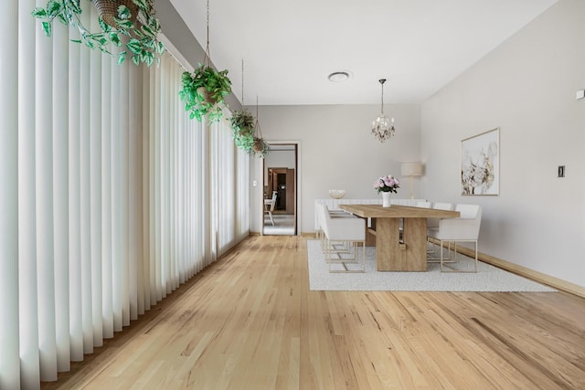 unfurnished dining area with a chandelier and light hardwood / wood-style floors