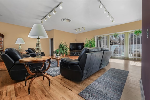 living room with track lighting and light hardwood / wood-style flooring