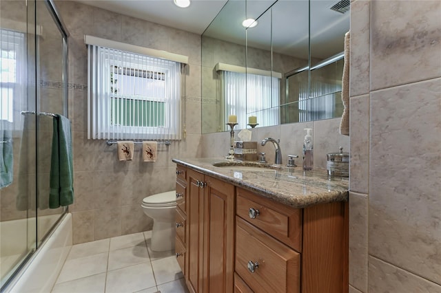 full bathroom with tile patterned floors, toilet, tile walls, and vanity