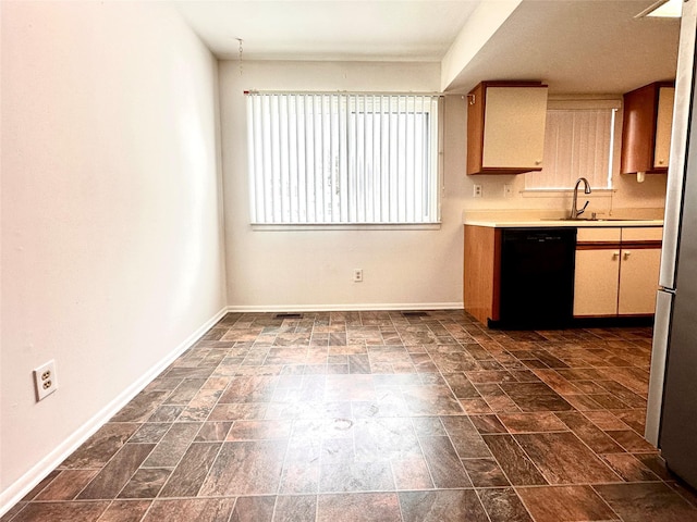 kitchen with sink, stainless steel refrigerator, and black dishwasher