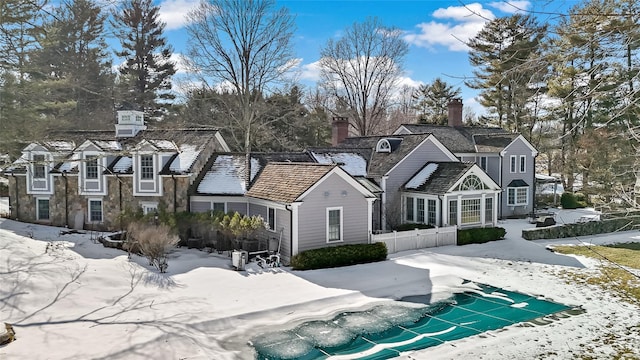 view of front of house with a chimney and fence