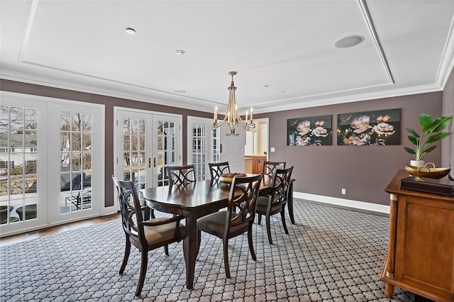 dining space featuring an inviting chandelier, baseboards, ornamental molding, and french doors