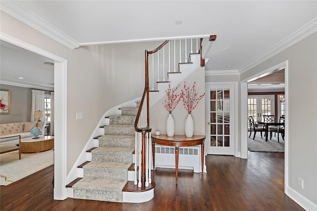 stairway featuring ornamental molding, a healthy amount of sunlight, and wood finished floors