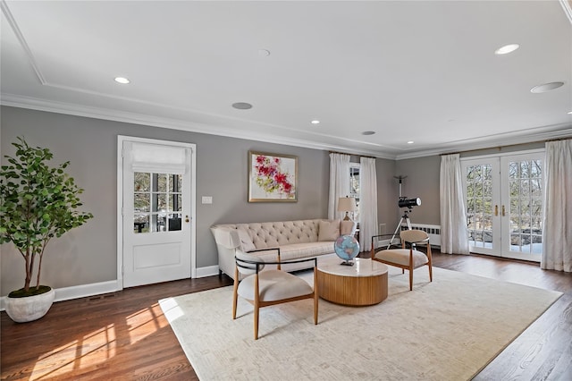 living room with a healthy amount of sunlight, baseboards, crown molding, and wood finished floors