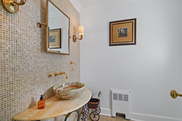 bathroom with ornamental molding, radiator, and baseboards