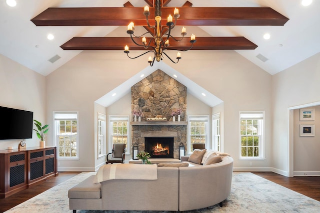 living area featuring a stone fireplace, a notable chandelier, visible vents, beam ceiling, and dark wood finished floors