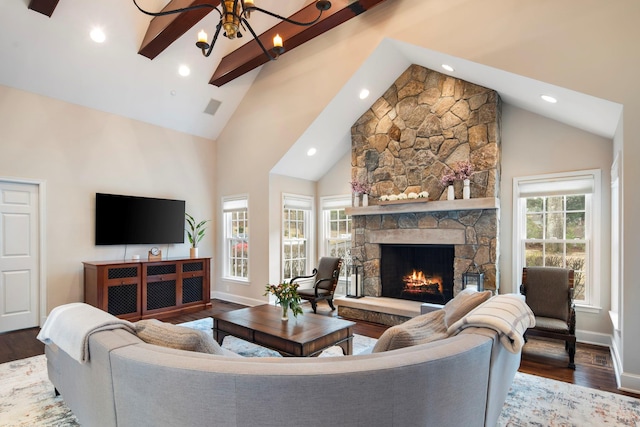 living room featuring plenty of natural light, visible vents, a fireplace, and wood finished floors