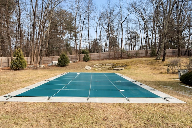 view of pool with a yard and a fenced backyard