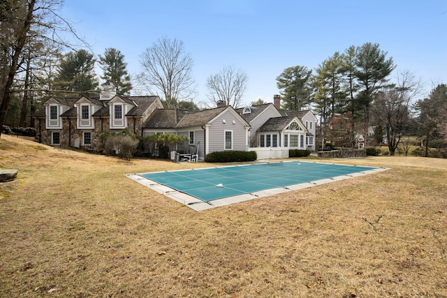 view of pool featuring a covered pool and a lawn