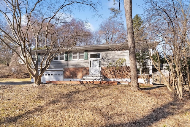 view of front of home featuring brick siding, an attached garage, and entry steps