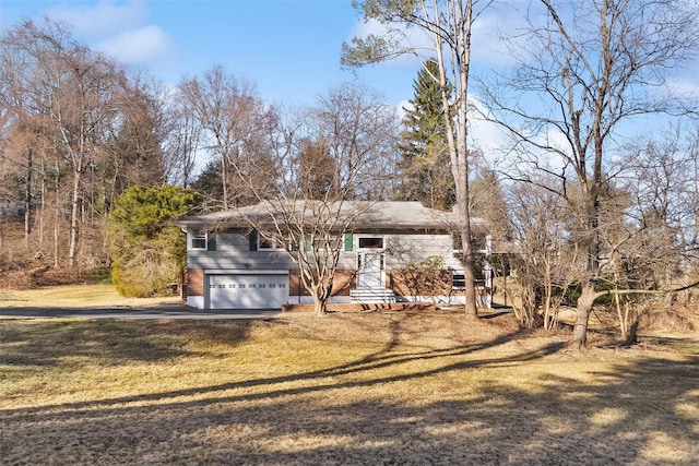 view of front of house with an attached garage and a front lawn