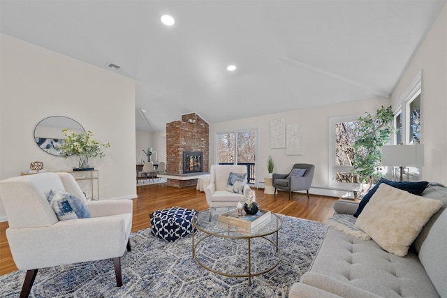 living area featuring wood finished floors, visible vents, lofted ceiling, recessed lighting, and baseboard heating