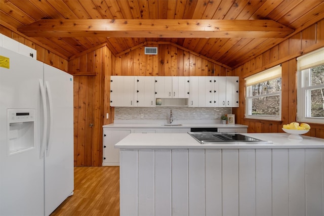 kitchen featuring a sink, black electric stovetop, white refrigerator with ice dispenser, and light countertops