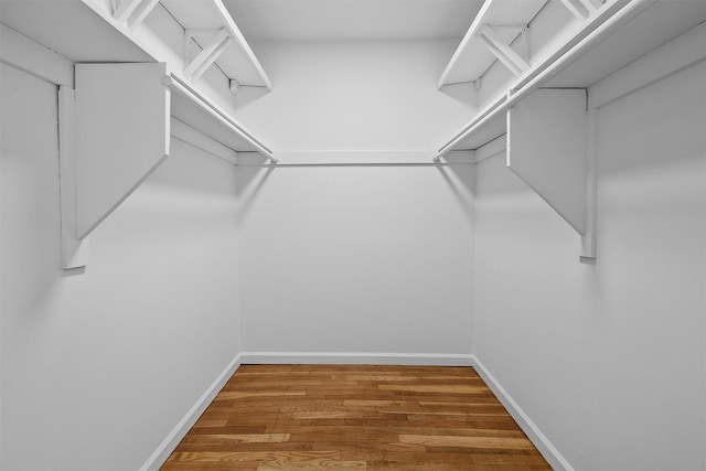 walk in closet with wood finished floors