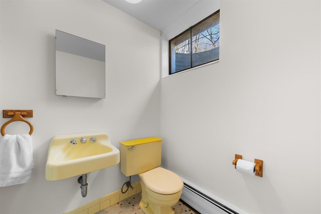 bathroom with baseboard heating, toilet, baseboards, and a sink