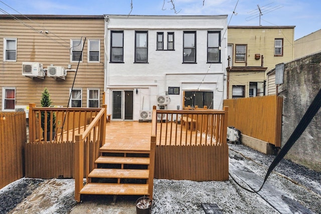 rear view of house featuring a wooden deck and an AC wall unit