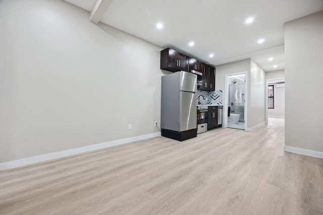 kitchen with stainless steel refrigerator, dark brown cabinetry, decorative backsplash, and light wood-type flooring